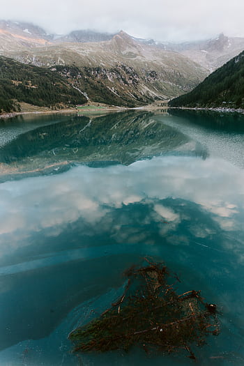 Explore the tranquil beauty of a mountain lake with pristine reflections under the dawn sky. HD phone wallpaper