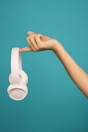 A hand gracefully holds wireless heads against a teal background. HD phone wallpaper