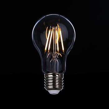 A detailed of an illuminated LED light bulb against a dark backdrop, emphasizing energy efficiency. HD phone wallpaper