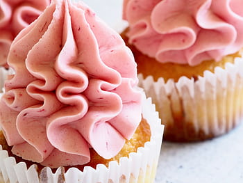 Delicious close-up of pink-frosted cupcakes, perfect for dessert enthusiasts. HD wallpaper