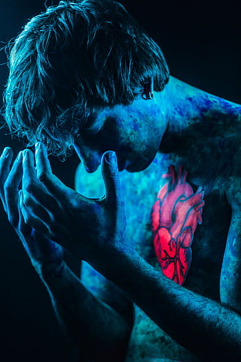 Conceptual portrait of a person with blue body paint and glowing red heart design. HD phone wallpaper