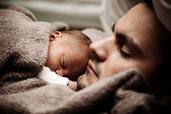 A touching close-up of a father and his baby peacefully napping together. HD wallpaper