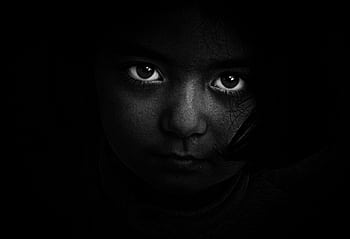 Intense black and white portrait of a child with captivating eyes, evoking mystery and emotion. HD wallpaper