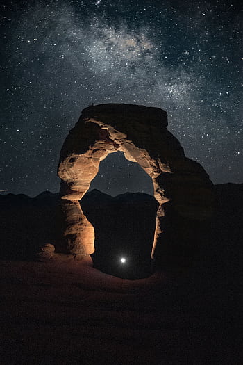 Milky Way above Delicate Arch in Utah's night sky, highlighting rock formations. HD phone wallpaper