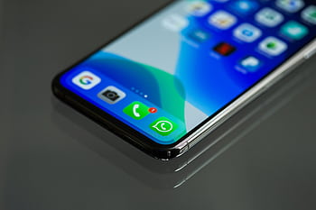 Close-up shot of a smart screen displaying various app icons including WhatsApp. HD wallpaper