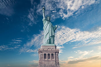 Iconic Statue of Liberty with a backdrop of a vibrant blue sky, symbolizing dom and America. HD wallpaper