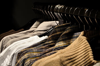 Organized display of various shirts on hangers, showcasing fashion and style. HD wallpaper