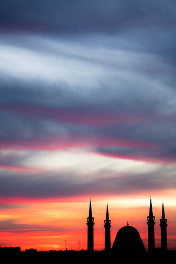 Silhouette of mosque minarets against a colorful sunset sky, capturing the beauty of architecture and nature. HD phone wallpaper