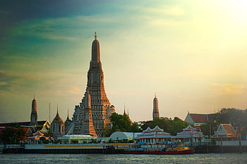 Stunning sunset view of Wat Arun temple by the Chao Phraya River in Bangkok, Thailand. HD wallpaper