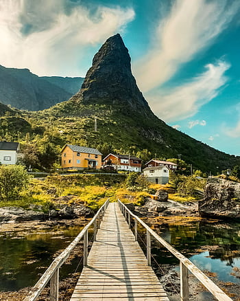 Explore the que landscape of Vågan, Nordland with a stunning wooden bridge leading to colorful houses. HD phone wallpaper