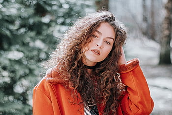 Captivating outdoor portrait of a young woman with curly hair in Vilnius park. HD wallpaper