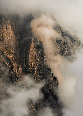 A serene view of mist-covered rocky mountains in Kranj, Slovenia, perfect for nature and adventure enthusiasts. HD phone wallpaper