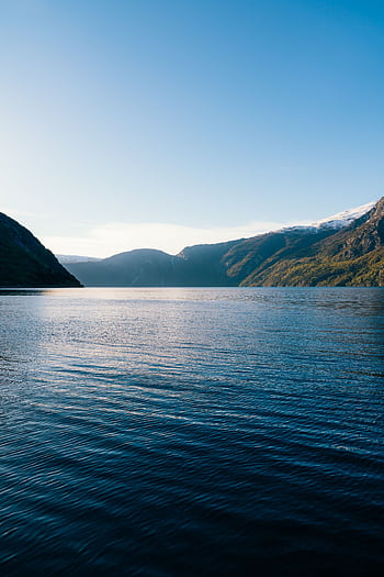 Serene landscape of Eidfjord in Hordaland, Norway, capturing the tranquil waters and majestic mountains at daybreak. HD phone wallpaper