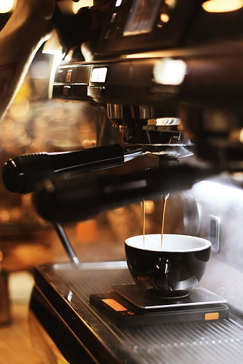 Close-up of espresso brewing process with modern coffee machine indoors. HD phone wallpaper