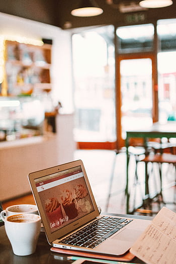 A cozy café setting with a laptop, coffee, and notebook, perfect for working or blogging. HD phone wallpaper