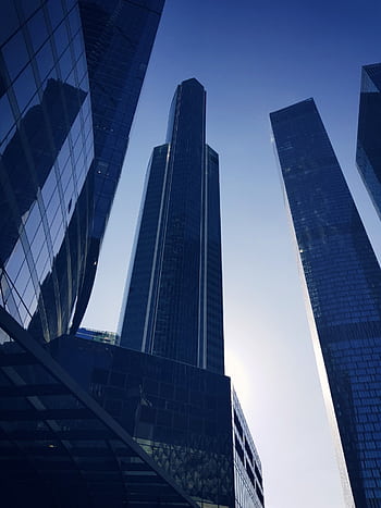 Low angle view of modern skyscrapers in Moscow with a striking morning sun backdrop. HD phone wallpaper