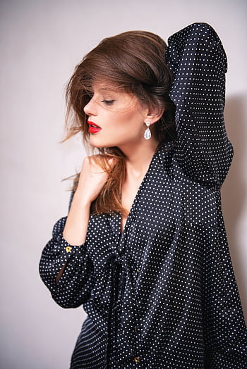 Stylish woman in polka dot outfit posing in a studio setting, showcasing modern elegance. HD phone wallpaper