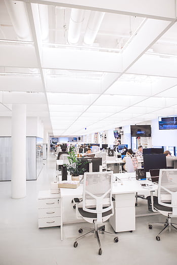 Spacious and well-lit office interior with modern furniture and workstations, ideal for a dynamic work environment. HD phone wallpaper