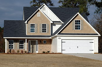 Elegant two-storey house with garage, showcasing modern architecture and residential charm. HD wallpaper