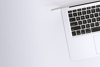 Aerial view of a sleek laptop keyboard on a clean, white surface, ideal for tech backgrounds. HD wallpaper