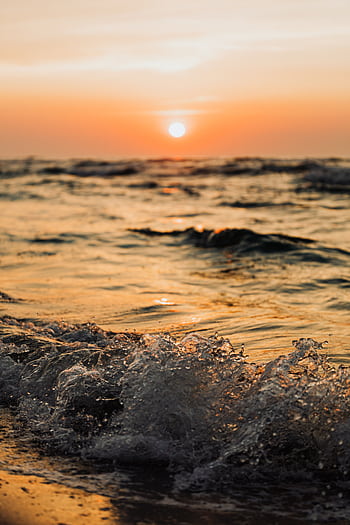 Stunning sunset view over the waves at Karwia Beach, Poland, capturing the tranquil beauty of the evening sea. HD phone wallpaper