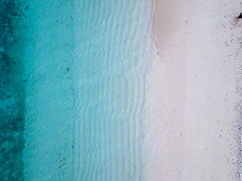 Aerial view of the beautiful turquoise ocean waves and pristine sandy beach in Fiji, perfect for a serene summer escape. HD wallpaper