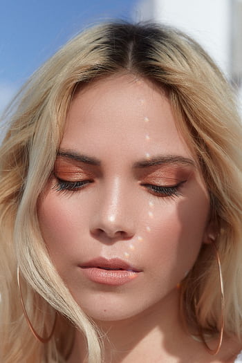 Close-up portrait of a woman with blond hair and eye makeup in natural light. HD phone wallpaper