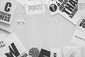 Monochrome flat lay of workspace with creative quotes and ears, embodying minimalism and design. HD wallpaper