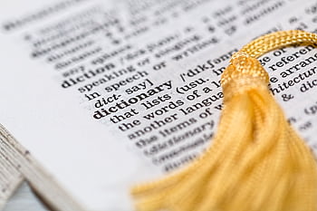 Close-up of a dictionary page focused on the word 'dictionary' with a yellow tassel. HD wallpaper