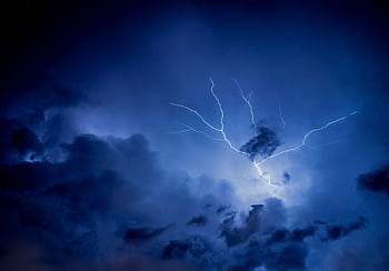 Dramatic lightning strike illuminating a dark, overcast night sky. HD wallpaper