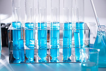 Close-up of blue liquid in test tubes for chemistry experiments in a laboratory setting. HD wallpaper