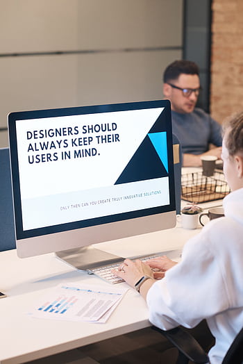 A focused designer works on a user-centric project in a modern office environment. HD phone wallpaper