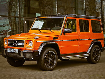 Bright orange Mercedes-Benz G Wagon parked in front of a building, showcasing luxury and style. HD wallpaper