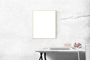A contemporary minimalist workspace featuring a blank frame on a concrete wall. HD wallpaper