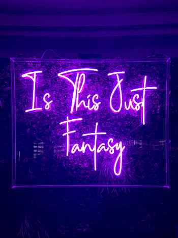 Purple neon sign with the text 'Is This Just Fantasy' glowing brightly against dark background. HD phone wallpaper
