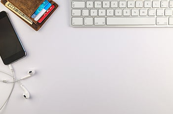 Flat lay of minimalist desk setup featuring a smart, keyboard, ears, and wallet for productivity inspiration. HD wallpaper