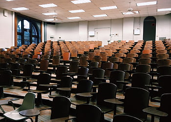 Empty university lecture hall with wooden chairs and large windows. HD wallpaper