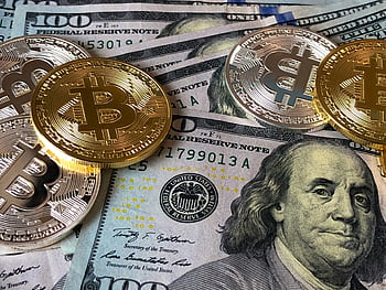 A close-up depicting Bitcoin coins on top of US dollar bills, symbolizing finance and cryptocurrency. HD wallpaper