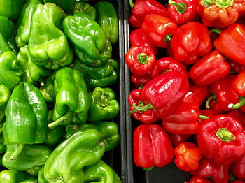 Close-up of vibrant red and green bell peppers at a market, showcasing fresh produce. HD wallpaper