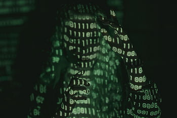 An unrecognizable person with binary code projected, symbolizing cybersecurity and digital coding. HD wallpaper