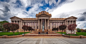 Front view of a neoclassical courthouse building in Colorado with lush greenery. HD wallpaper