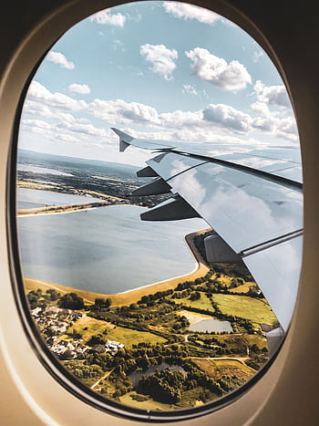 Scenic view of landscape through an airplane window with visible wing and sky. HD phone wallpaper