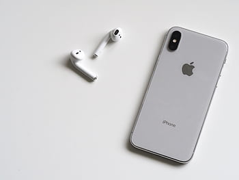 Close-up of a silver and wireless AirPods on a sleek white background. HD wallpaper