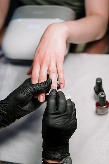 Close-up of a professional manicure with gel polish and black gloves in a salon. HD phone wallpaper
