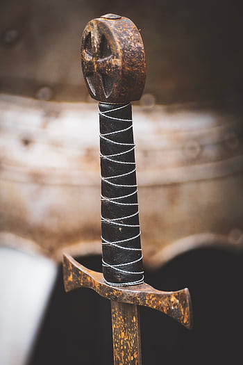 Detailed of a rusted medieval sword handle showing age and craftsmanship. HD phone wallpaper