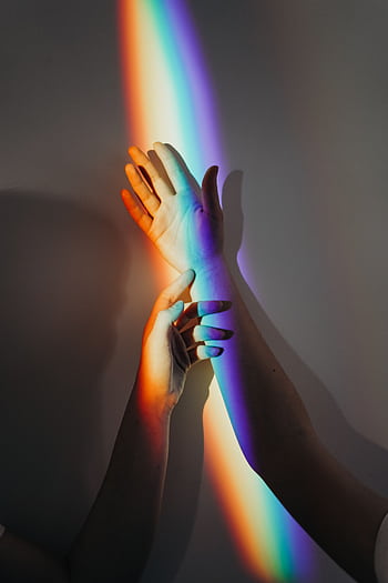 A beautiful display of rainbow light casting on intertwined hands symbolizing unity and love. HD phone wallpaper