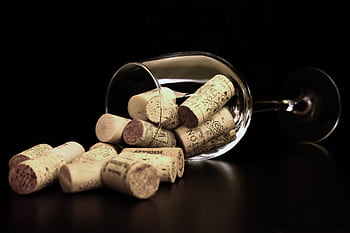 Wine corks spilling from a glass in a close-up arrangement. HD wallpaper