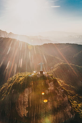 Breathtaking aerial graph of Christ the Redeemer with sun rays over Rio de Janeiro, Brazil. HD phone wallpaper