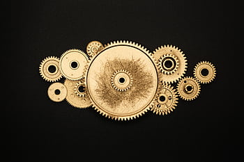 Artistic arrangement of gold gears on a black background symbolizing industry. HD wallpaper