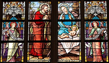 Vibrant stained glass window illustrating a biblical nativity scene with vivid colors in a church setting. HD wallpaper